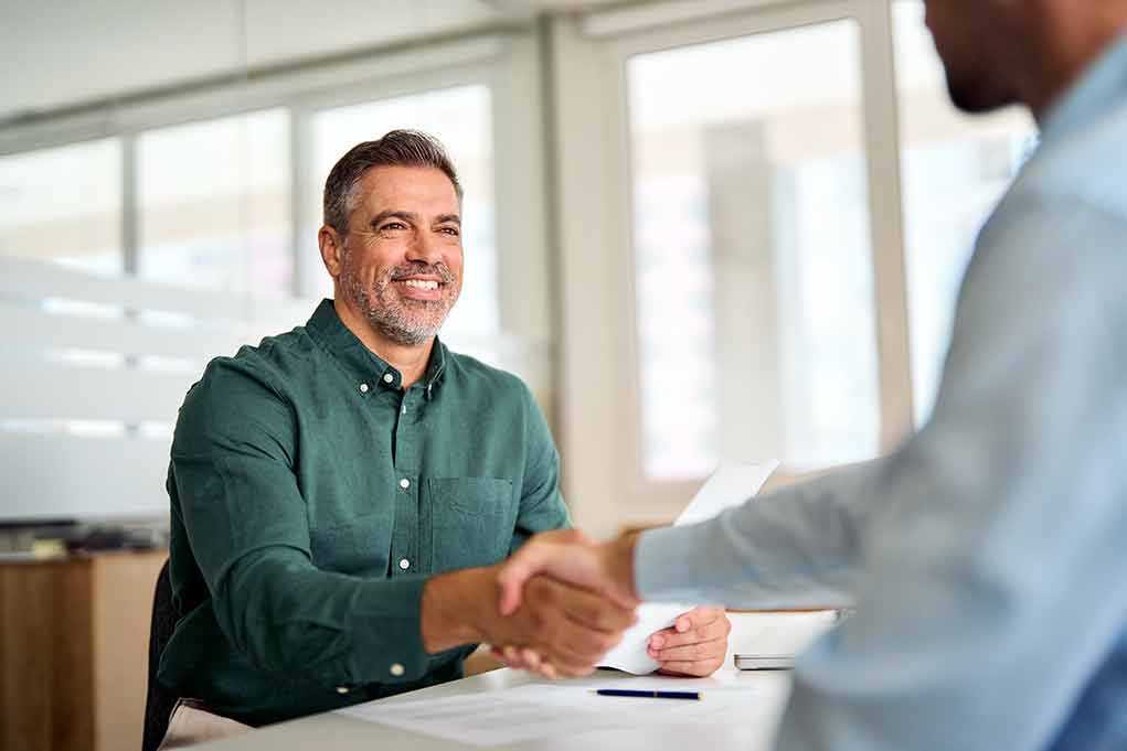 Two professionals shaking hands in an office setting