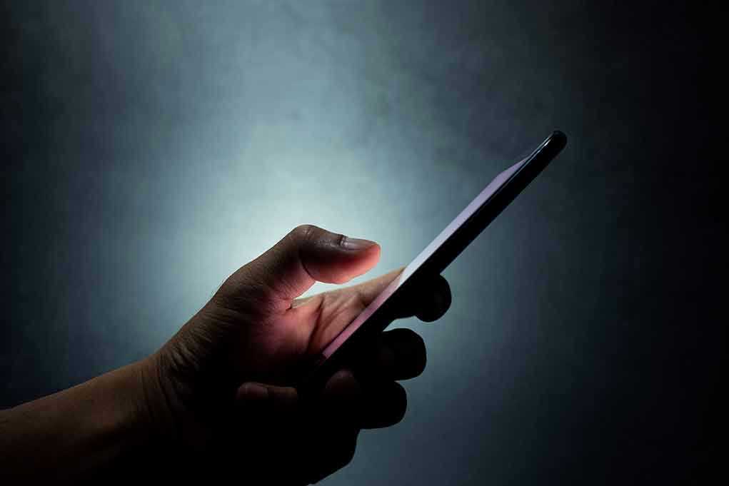 Hand holding a smartphone in the dark