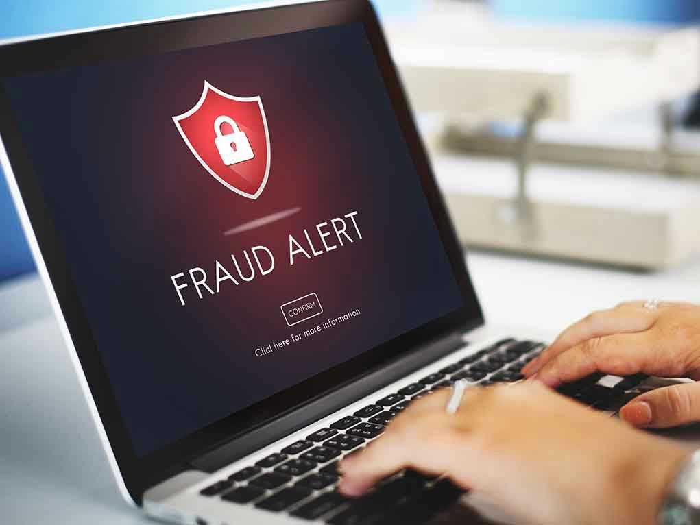 Laptop displaying fraud alert warning on screen