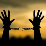 Year-Long Captivity Ends With Shocking Twist Hands breaking free from chains at sunset.