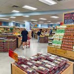 Interior of a grocery store with customers shopping for fresh produce