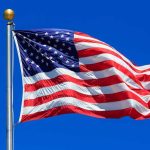 Patriotism REVIVAL: PragerU Shakes Up Schools Waving American flag against a clear blue sky