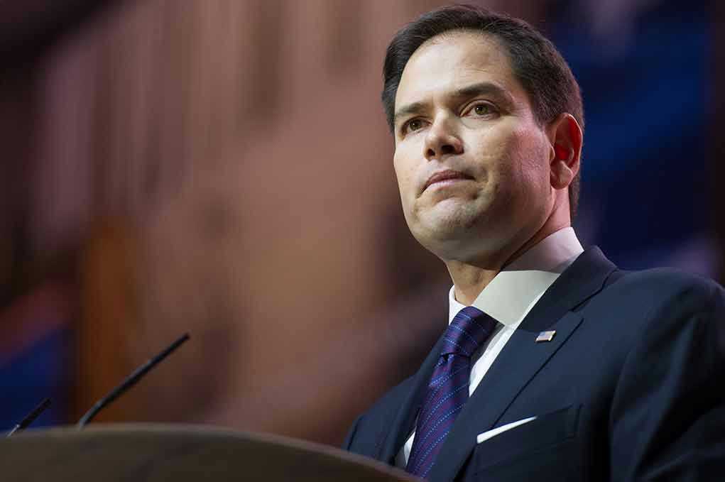 Man in suit speaking at podium.