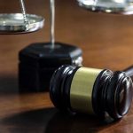 Hospital Exec Walks Free—Judge’s Call Under Fire Gavel and scales of justice on wooden table.