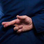 Deadly Seduction Trap CLAIMS Three Lives Person crossing fingers behind their back in suit