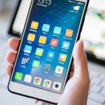 Apple Calendar Scam Bypasses Every Defense A person holding a smartphone displaying various mobile applications