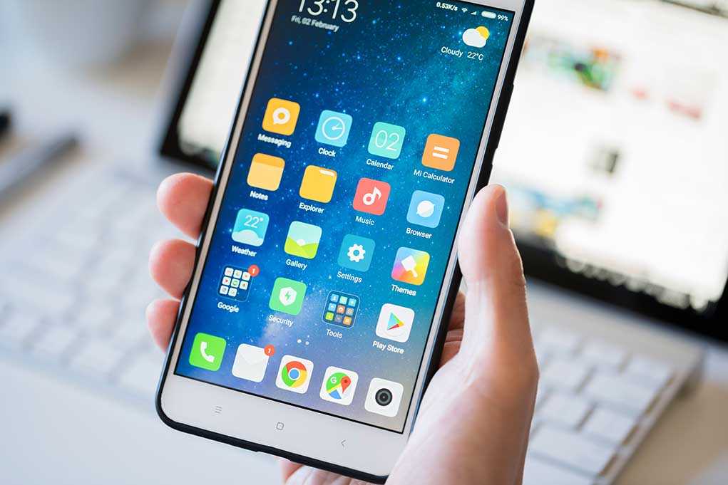 shutterstock_1022739907.jpg A person holding a smartphone displaying various mobile applications