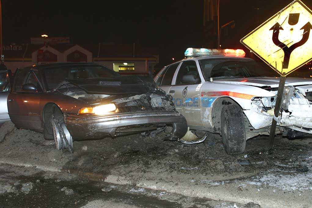 shutterstock_2842305.jpg A damaged car and a police vehicle involved in a nighttime accident