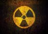 Nuclear Smuggling SHOCK – Chinese Trio Arrested Yellow radiation warning symbol on rusty metal surface.