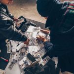 Brothers STEAL $25 Million in 12 Seconds Two individuals handling stacks of money on a table.