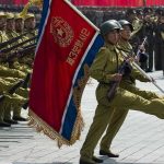 Women Hunted Over Implants—Regime’s Bizarre Crackdown Soldiers marching with rifles and a red flag