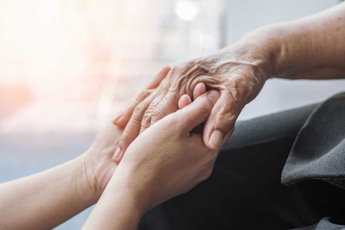 1702101469 Young hands holding an elderly persons hand.