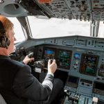 Mid-Air Mystery STUNS United—Pilot Hurt at 36,000 Feet Pilot in cockpit operating airplane controls.