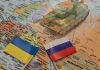 Putin-Trump Call Sparks White House Uproar Toy tank on map with Ukraine and Russia flags.