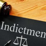 Espionage Bombshell — Top Trump Critic Indicted Gavel next to indictment document on table