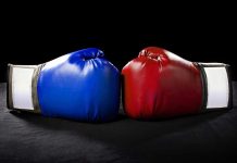 Blue and red boxing gloves facing each other.