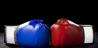 Blue and red boxing gloves facing each other.