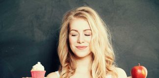 Woman holding a cupcake and an apple