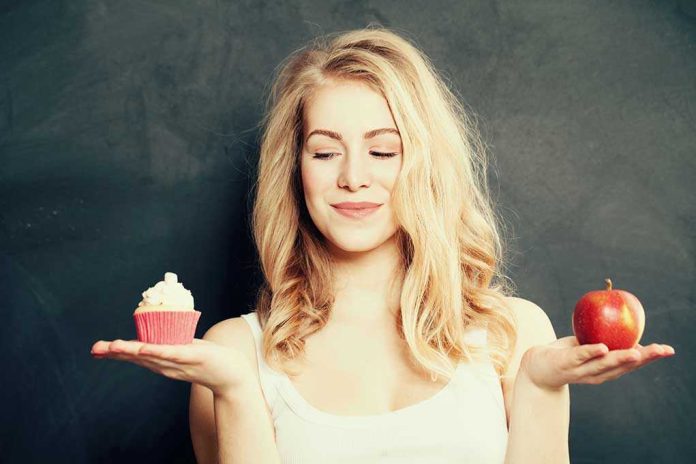 285292964 Woman holding a cupcake and an apple