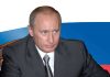 A serious-looking man in a suit sitting at a table with a Russian flag in the background