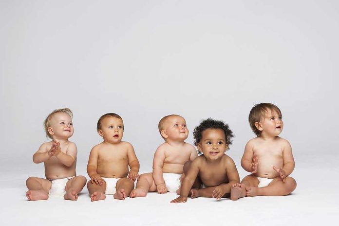 shutterstock_144900970.jpg Five diverse babies sitting on a neutral background, displaying playful expressions
