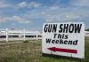 Sign advertising a gun show happening this weekend with an arrow pointing left