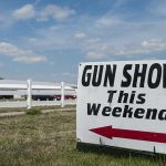 Sign advertising a gun show happening this weekend with an arrow pointing left