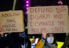 BURNOUTS Terrorize Major City — Police STRIPPED Away! Two individuals holding protest signs with messages about police reform