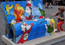A colorful bench featuring Dr. Seuss characters with a child playing nearby