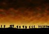 Sudden Snowstorm Traps 20 Hikers – Rescue Drama! Silhouetted figures walking against a sunset backdrop