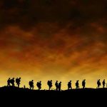 Sudden Snowstorm Traps 20 Hikers – Rescue Drama! Silhouetted figures walking against a sunset backdrop