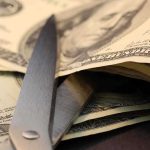 Blue State SPENDS Double on Illegals vs Police Scissors cutting through a stack of dollar bills