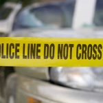 Wisconsin Horror Stuns Police Yellow police tape in front of a car.