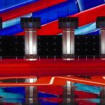 Four debate podiums on a CNN stage background.