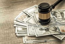 Gavel on a pile of hundred-dollar bills.