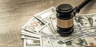 Gavel on a pile of hundred-dollar bills.