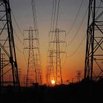 Energy Giant BUSTED for 230% Price Hike Transmission towers at sunset.