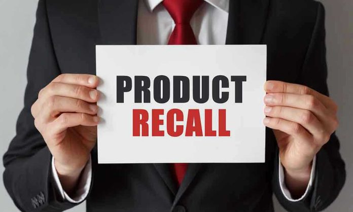 741529771 Product Recall sign held by person in suit.