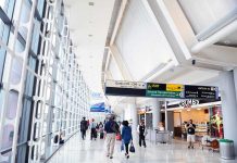 FAA SLASHES Flights — New MANDATE Shakes Travelers People walking in a brightly lit airport terminal.