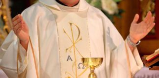 A priest performing a religious ceremony with a golden chalice