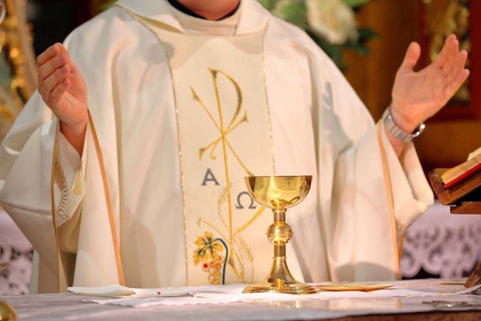 A priest performing a religious ceremony with a golden chalice