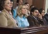 A group of jury members sitting in a courtroom with serious expressions