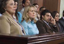 A group of jury members sitting in a courtroom with serious expressions