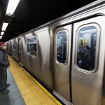 A commuter waiting at a subway station as a train approaches