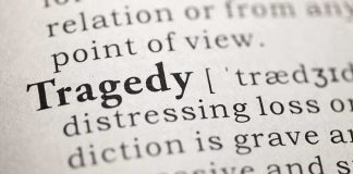Close-up of the word 'Tragedy' in a dictionary with its definition