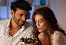 A couple sharing a plate of desserts in a cozy indoor setting