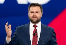 MAGA Civil War Erupts Over 2028 Ambush Man in a suit speaking at an event.