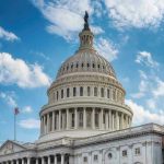 U.S. Capitol building dome under clear blue sky.
