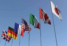 Italy BANS Woke Ideology — Leftists MELT DOWN! Flags of seven countries against clear blue sky.