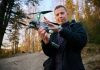 Cheap Kamikaze Drone Upends U.S. War Playbook Person holding a drone in a forest.